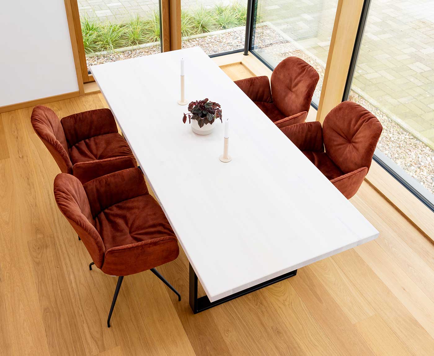 Weiße Tischplatte aus Massivholz mit vier roten Stühlen und Dekoration