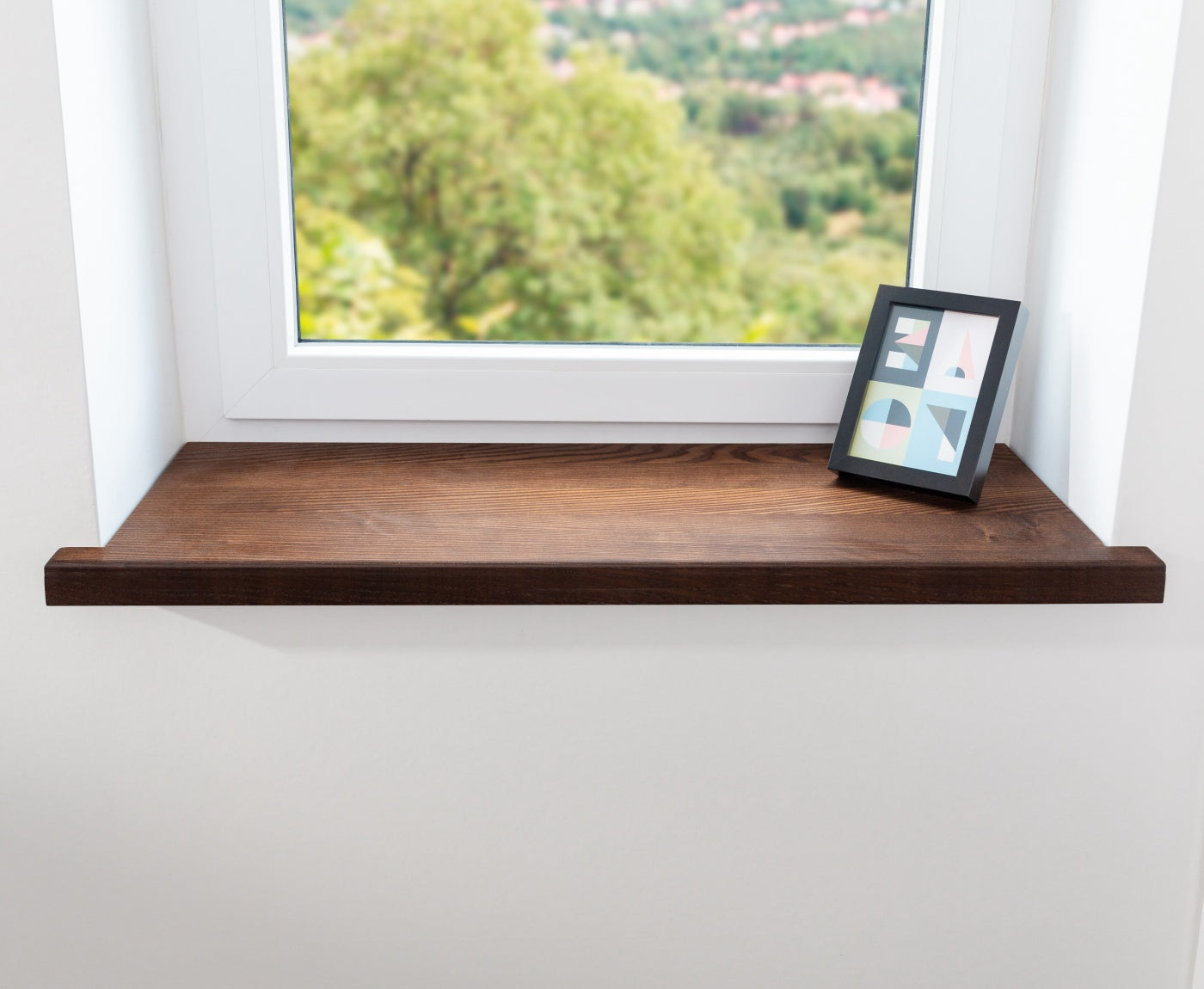 Frontansicht von Fenster mit brauner Aufsatzfensterbank aus Eschenholz und Bilderrahmen