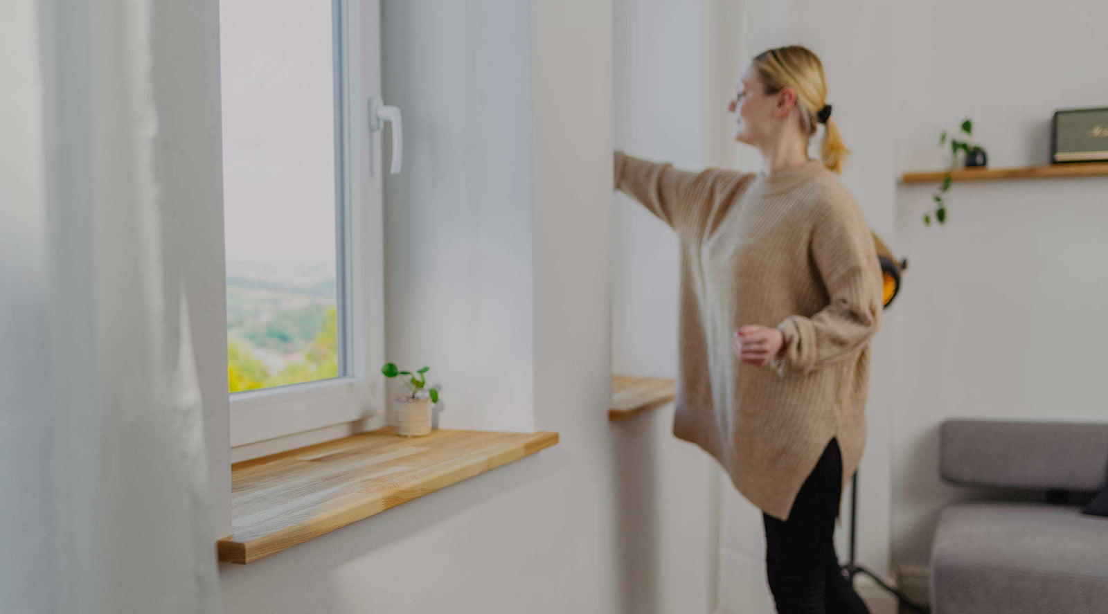 Frau geht zum Fenster und öffnet dies