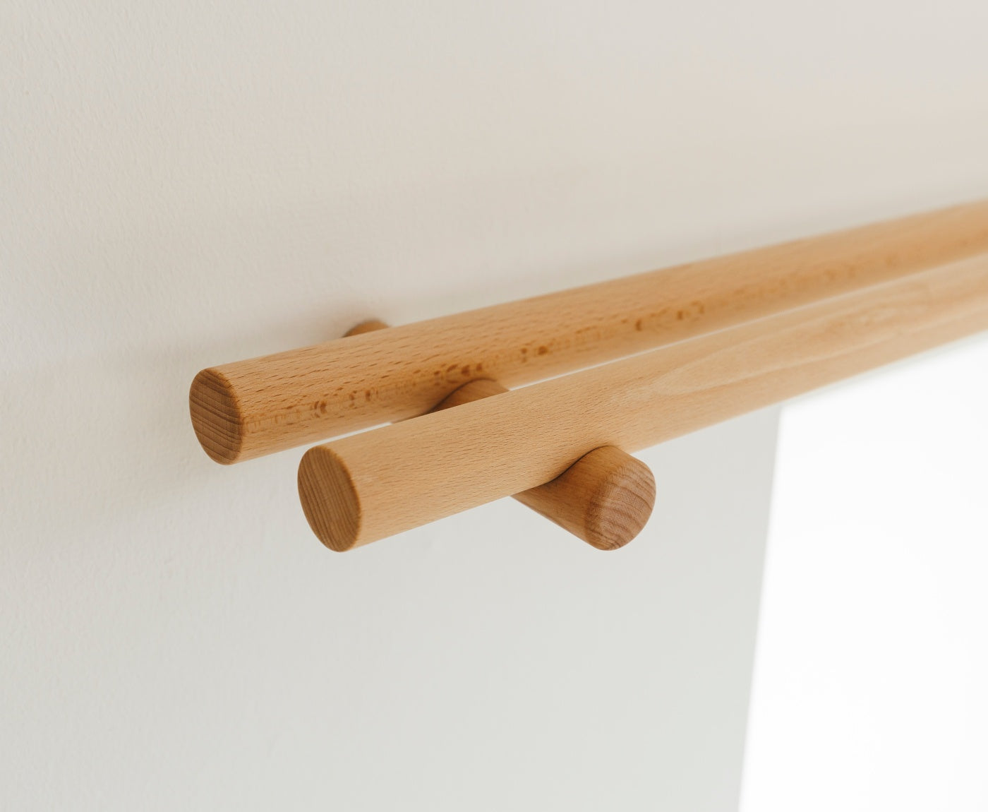 Nahaufnahme von Enden und Halterung der Gardinenstange aus Buche doppelt