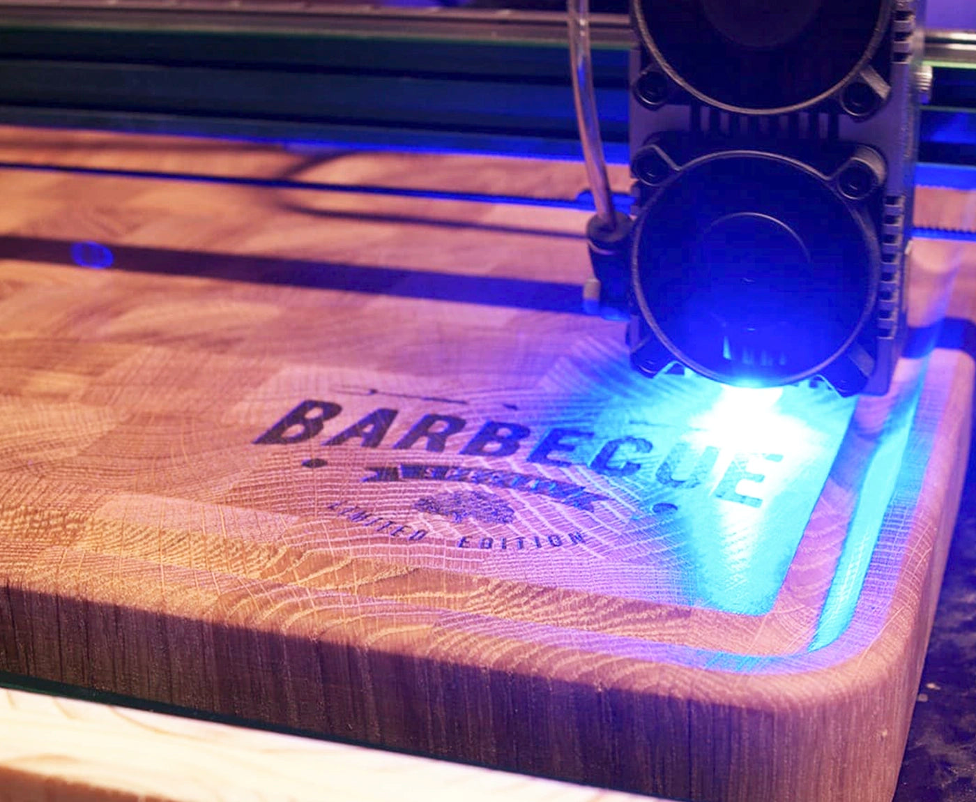 Laser bei der Gravur des Schriftzugs "Barbecue" auf Stirnholz Schneidebrett