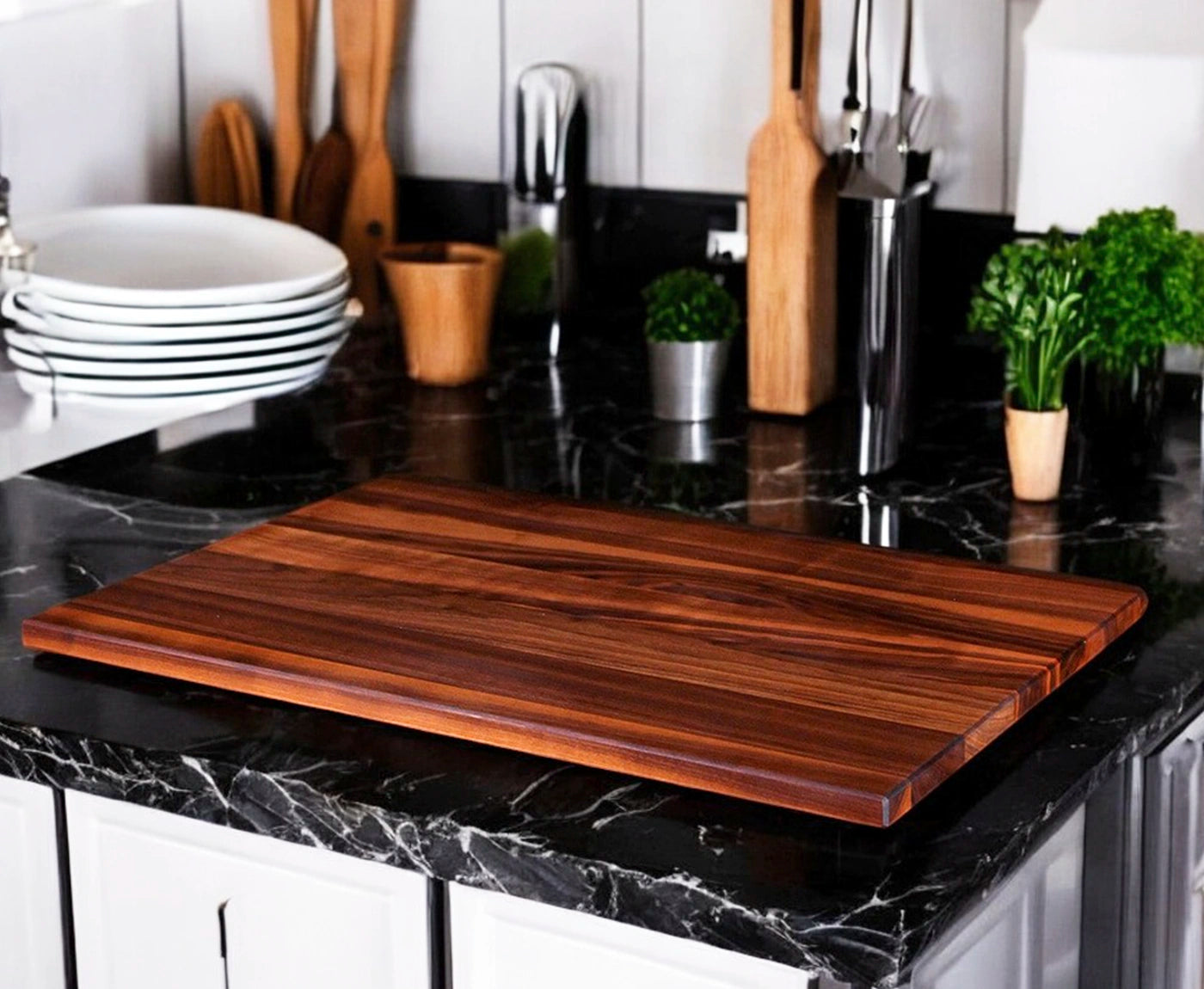 Abdeckplatte für Ceranfeld aus Nussbaum auf schwarzer Kücheninsel, mit Pflanzen und Küchenutensilien.