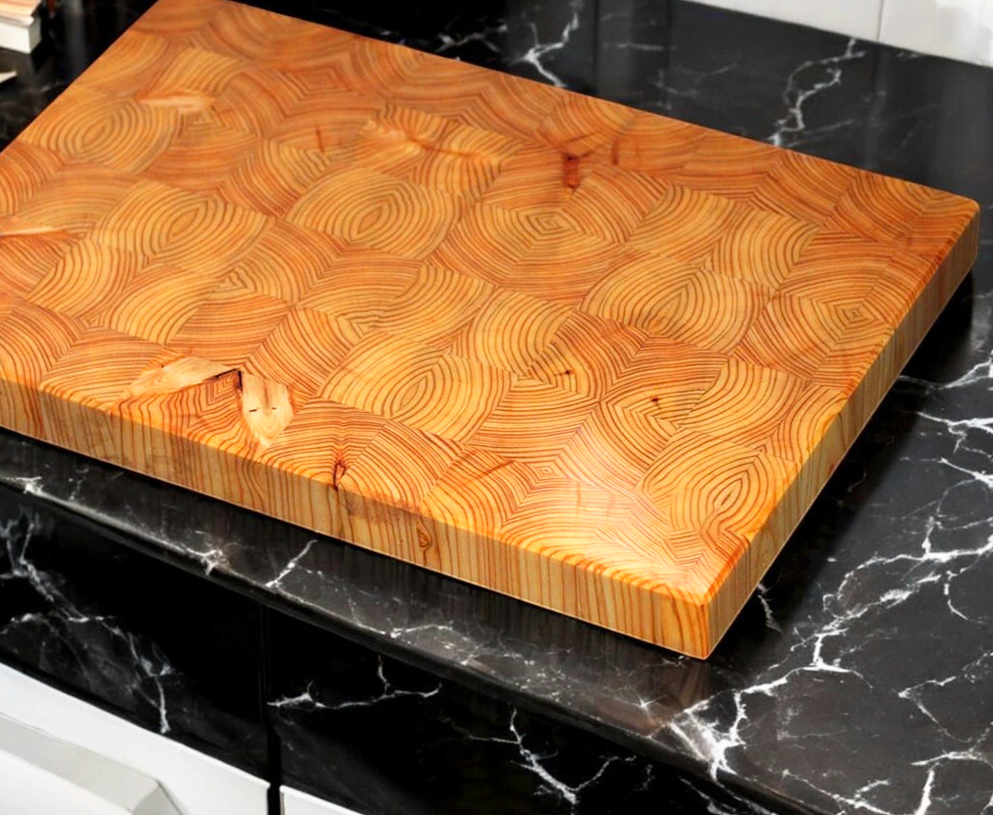 Stirnholz Schneidebrett aus Lärche auf schwarzer Küchenarbeitsplatte.