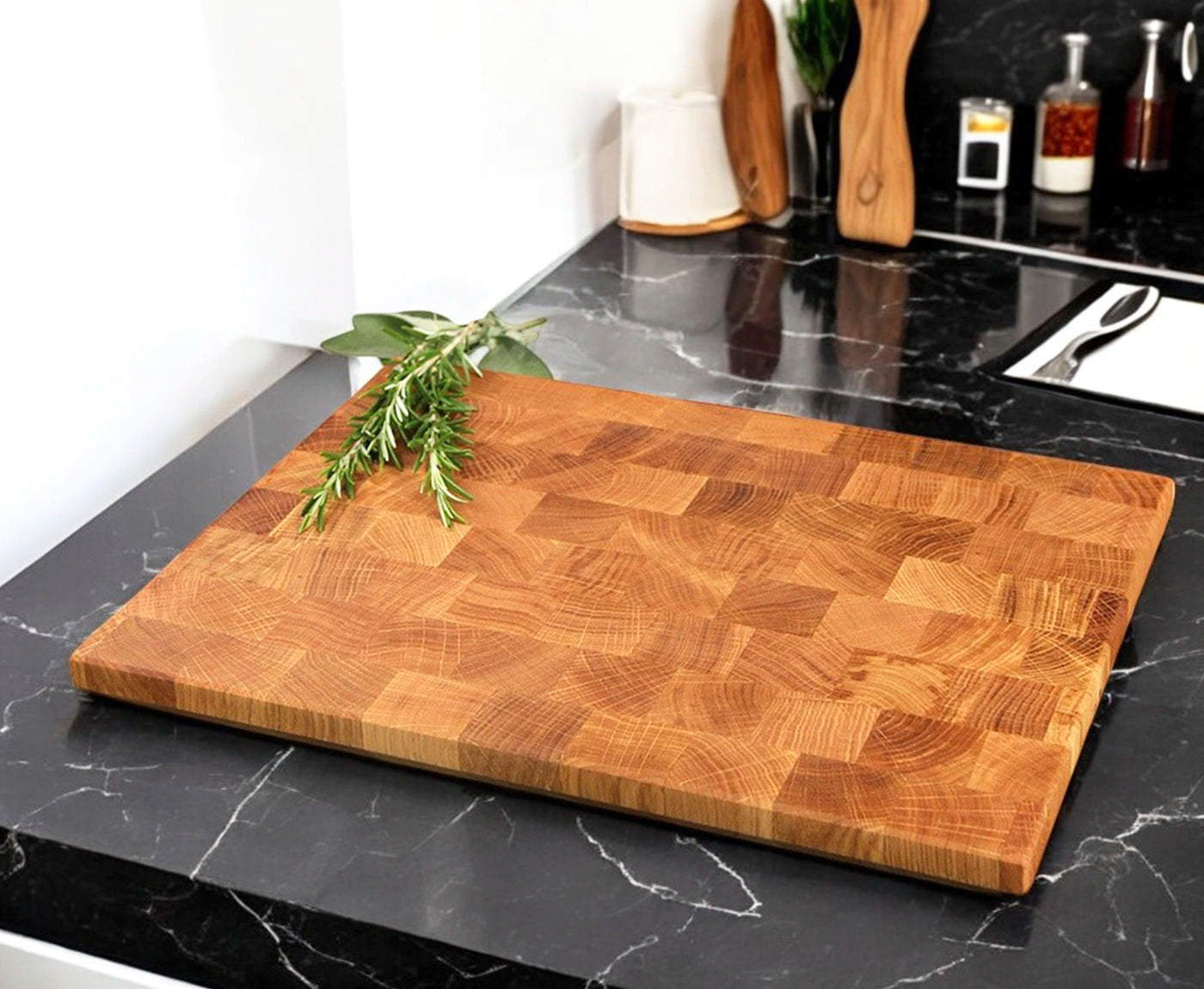 Stirnholz Schneidebrett mit Schweizer Kante aus Eiche, mit Kräutern und Küchenutensilien.