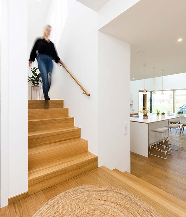 Junge Frau greift einen Handlauf während sie die Treppe nutzt